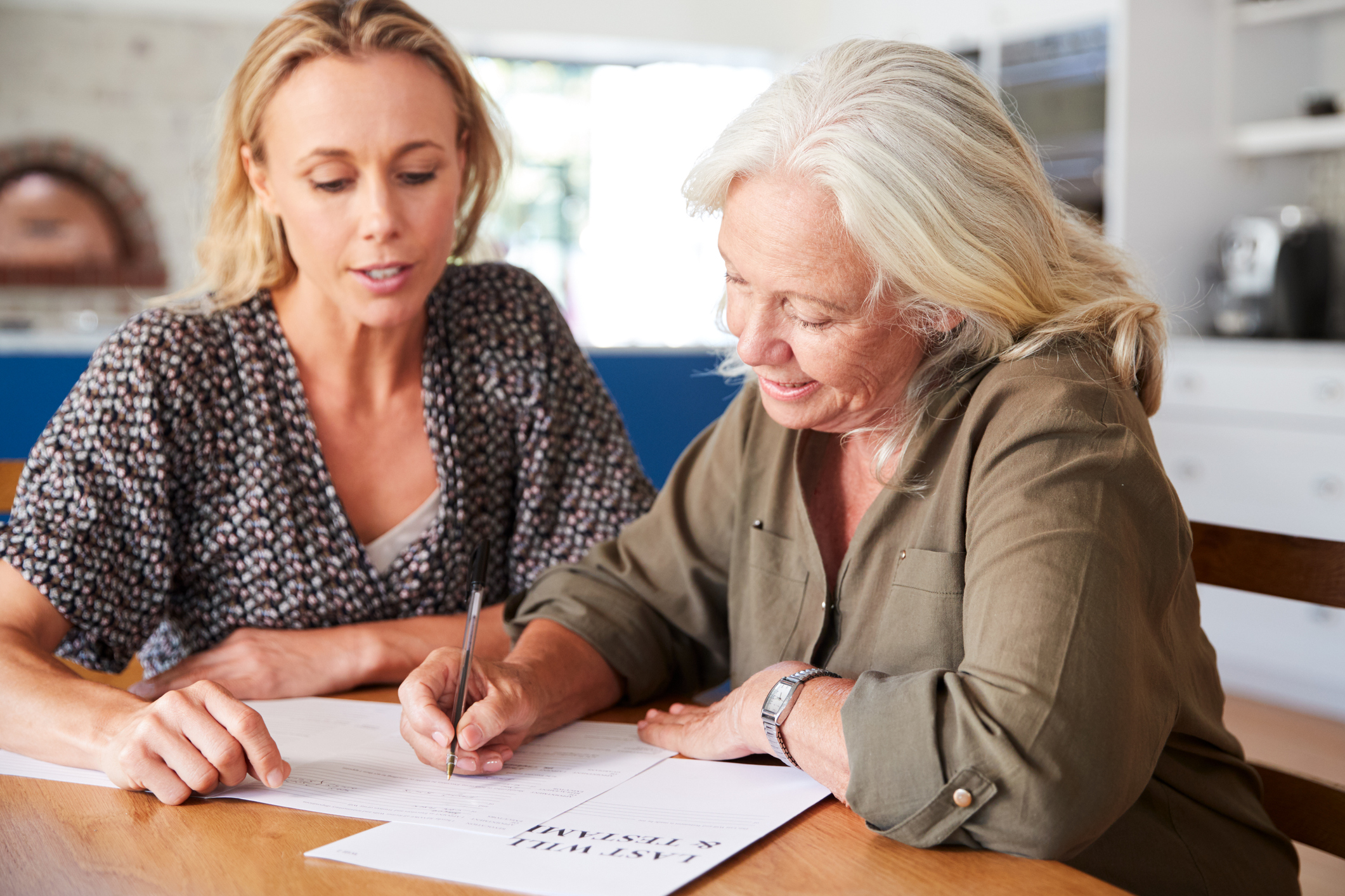 Younger Woman helping Older Woman fill out Last Will